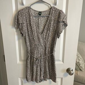 Gray and white floral print romper with tie belt and short flutter sleeves.